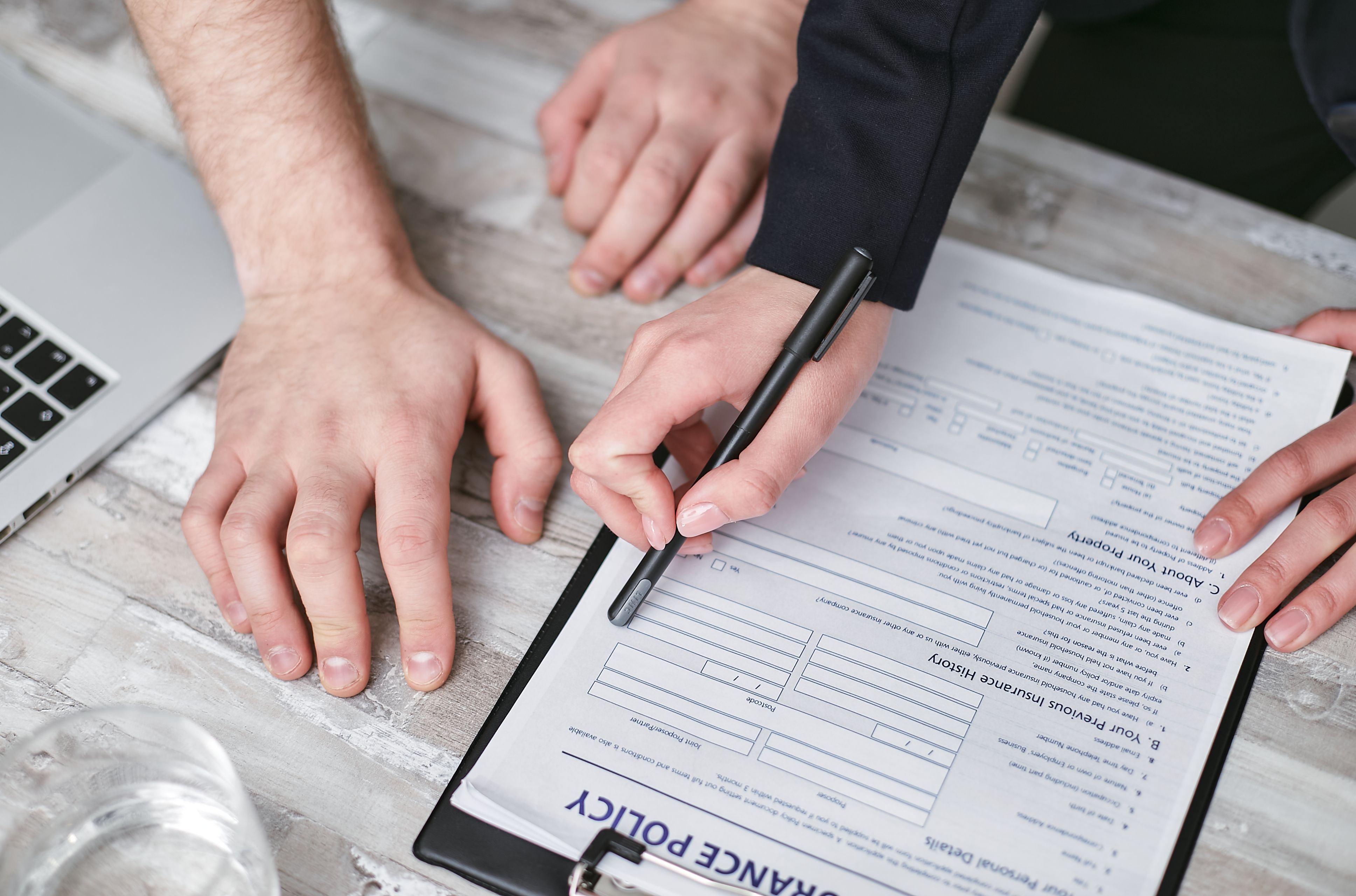 Deux mains qui signent un contrat d'assurance